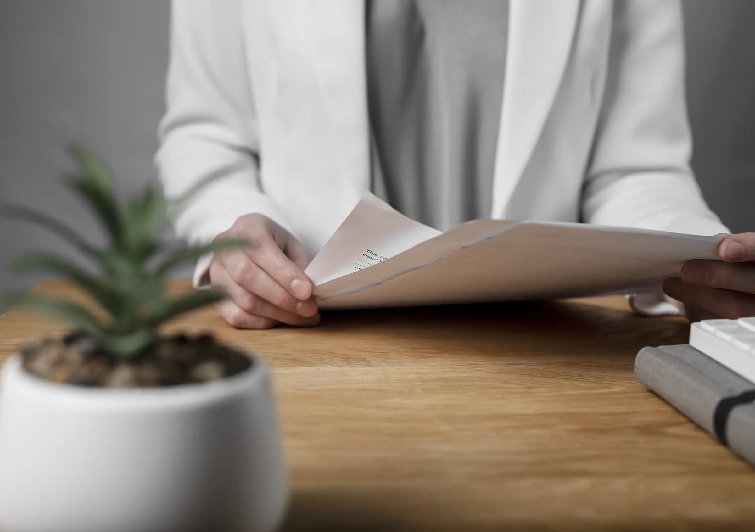 Hands holding a printed document over a timber desk